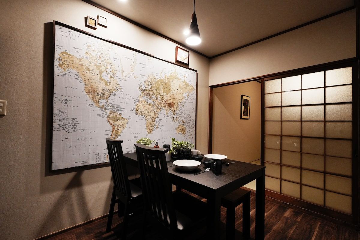 大きな世界地図と黒い大テーブルのある部屋